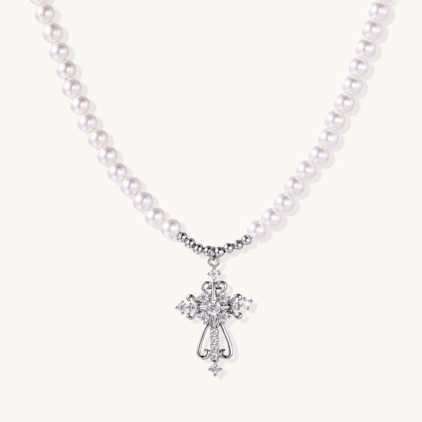 Elegant pearl necklace with ornate 18K gold plated cross pendant featuring zirconia stones on neutral background.