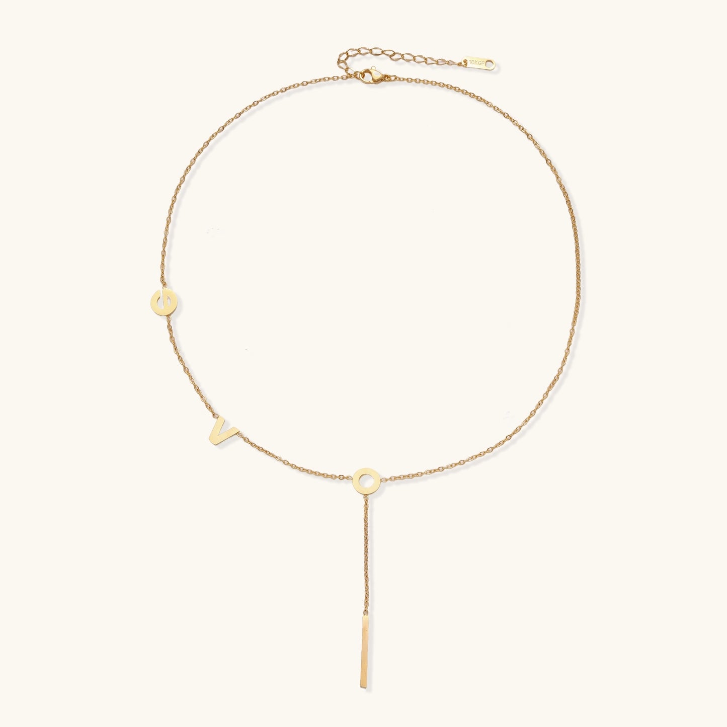 Gold-plated lariat necklace spelling LOVE with letter charms and vertical bar pendant on white background.