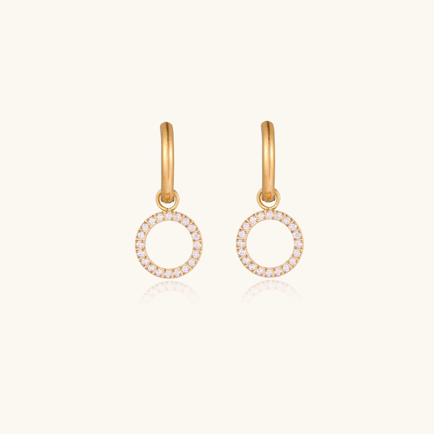 Gold-plated hoop earrings with circular cubic zirconia charm dangles displayed on neutral background.