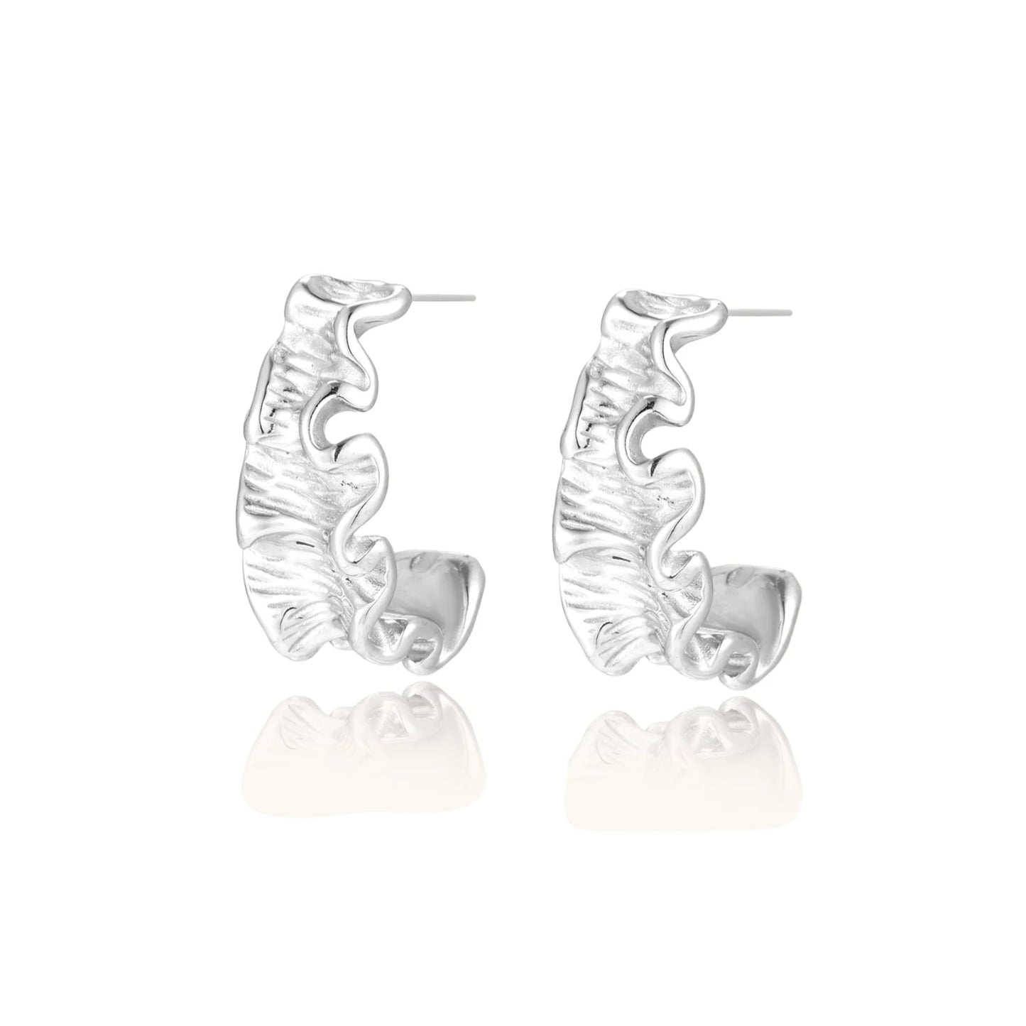 White gold plated sculptural hoop earrings with organic wavy edges and reflective metallic finish on cream background