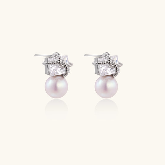 Gold-plated stud earrings with square crystal tops wrapped in twisted wire and freshwater pearl drops on white background