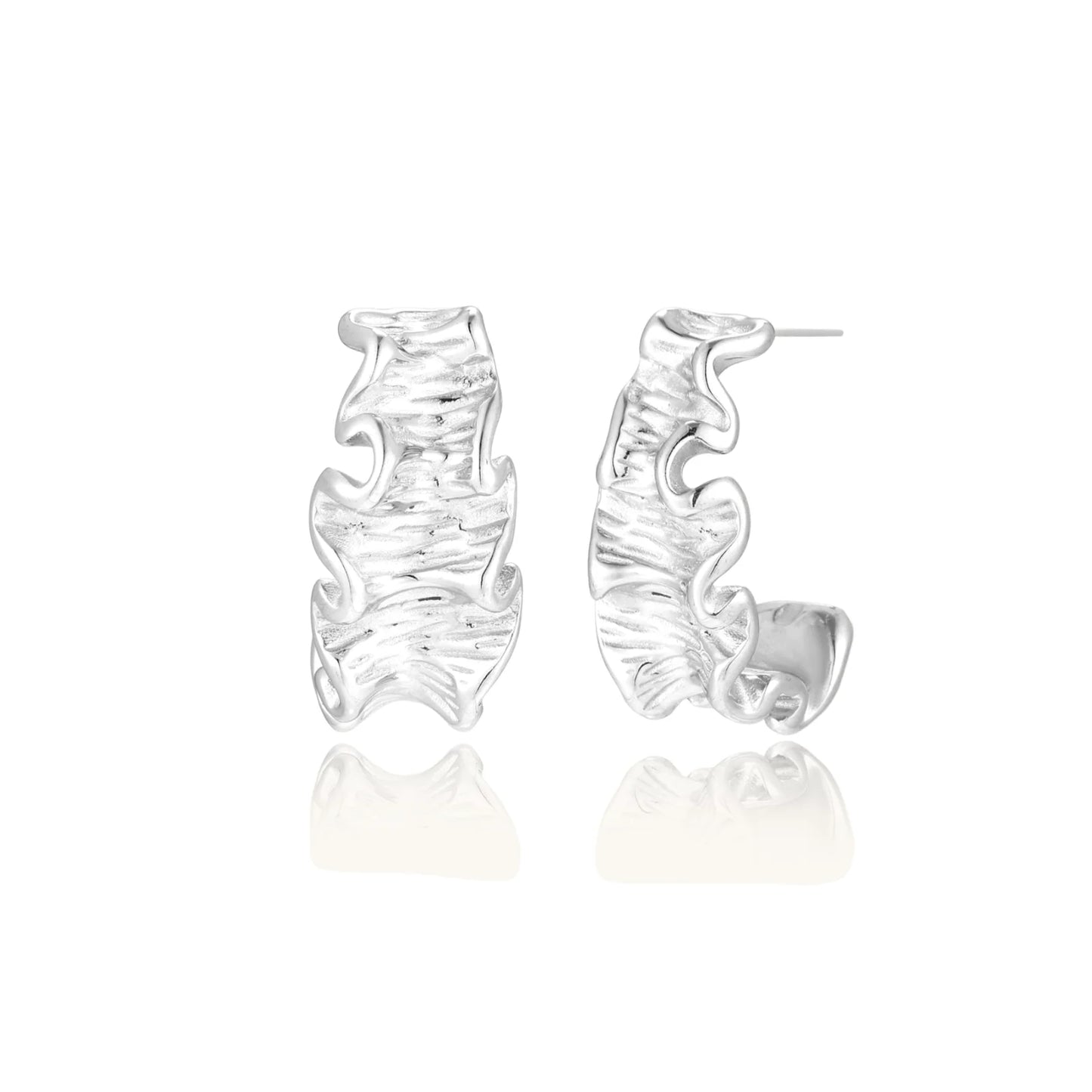 White gold plated sculptural hoop earrings with organic wavy edges and reflective metallic finish on cream background