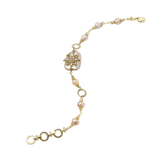 Gold-plated bracelet with pink baroque pearl centerpiece, floral connector, and freshwater pearls
