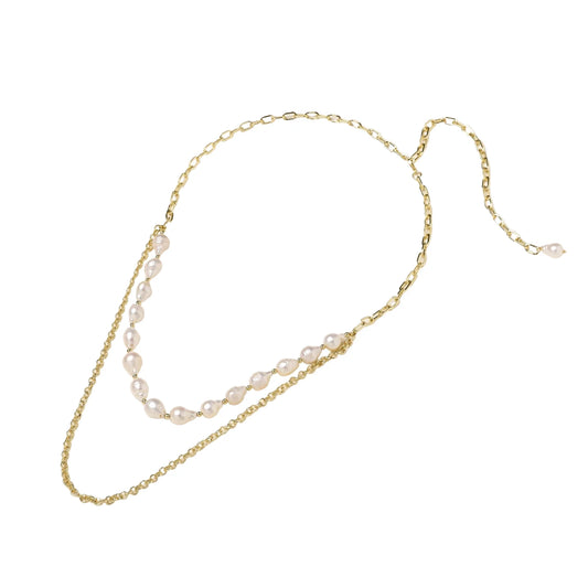 Layered gold chain necklace with organic baroque freshwater pearls and adjustable length on cream background